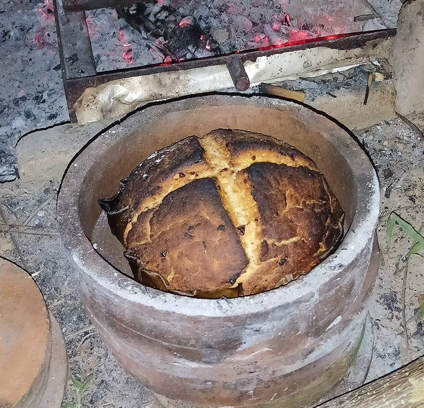 Bread baking in a clay pot over fire