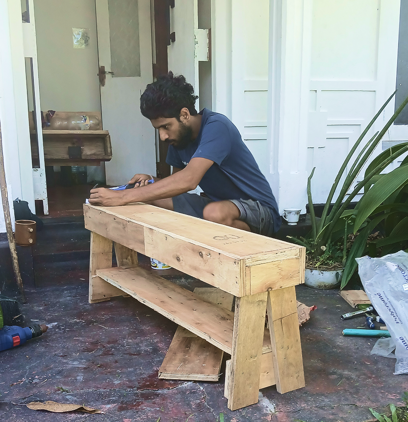 Local worker building reclaimed wood furniture